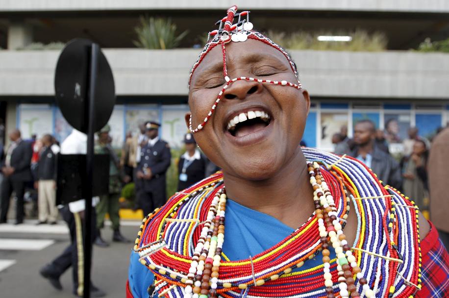 Una donna in abiti tradizionali Masai attende i campioni keniani. Reuters